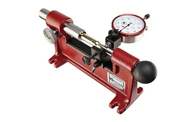Hornady Lock-N-Load concentricity gauge in red on a workbench